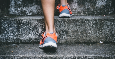 Feet in trainers walking up stairs